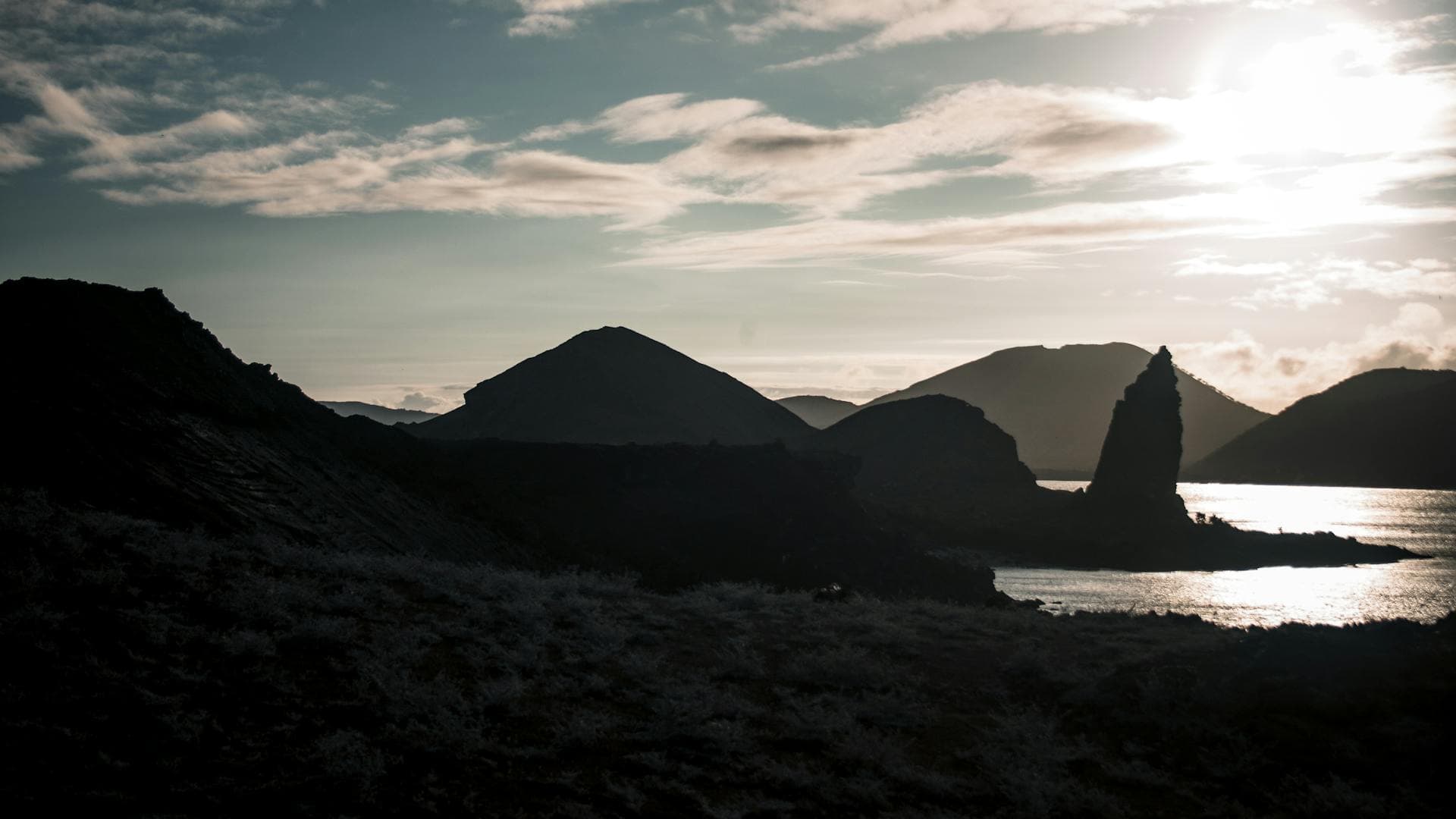 Pinnacle Rock on Bartolome Island silhouetted against a dramatic sunset in the Galapagos Islands