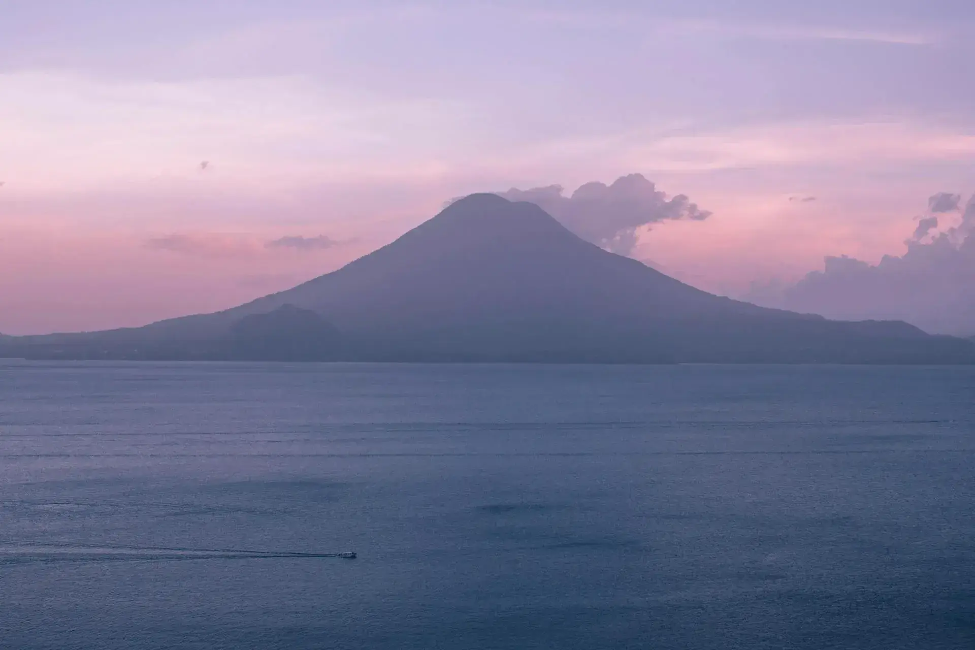 Lake Atitlan at sunset framed by volcanic peaks in Guatemala