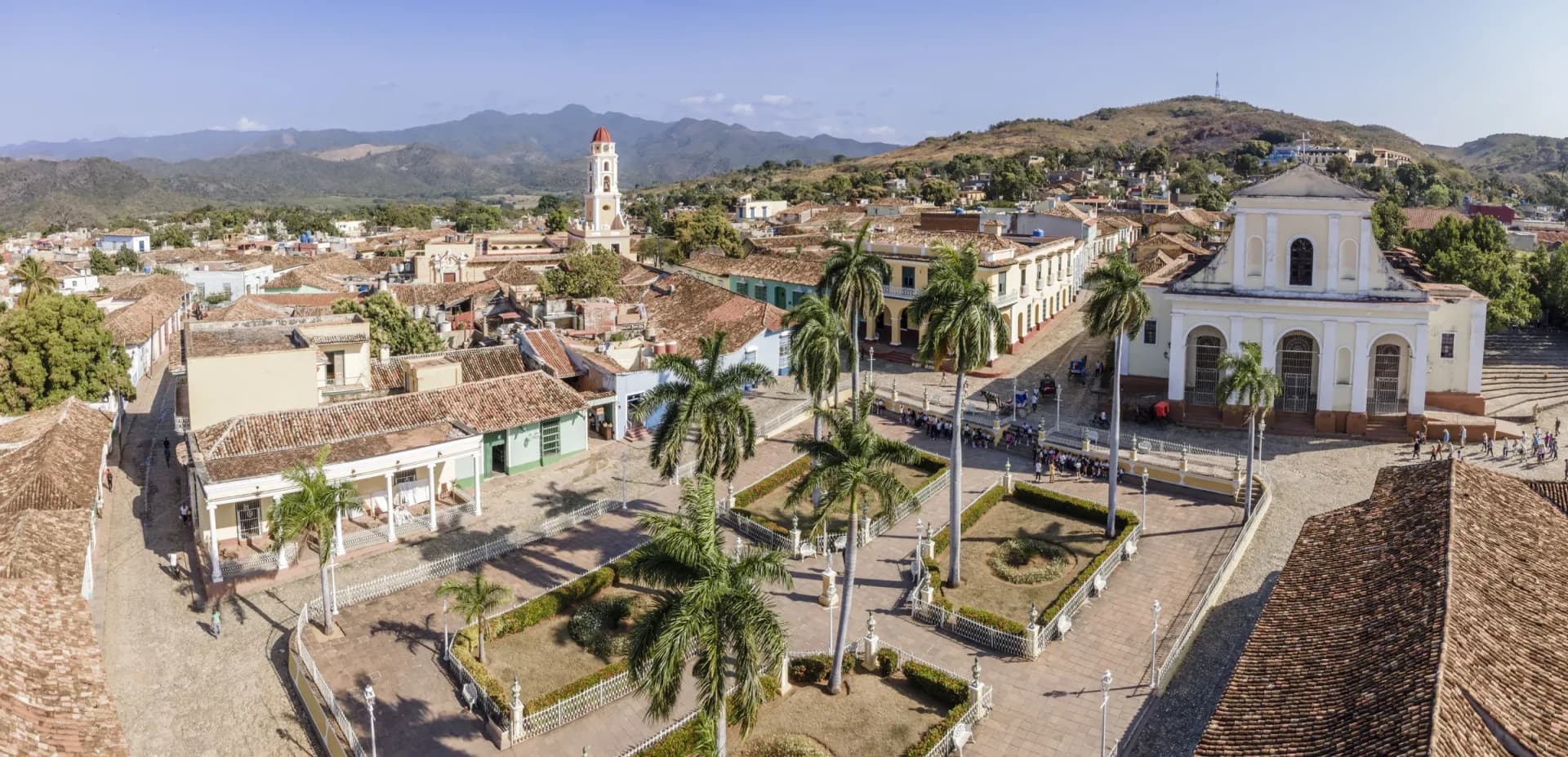 Plaza Mayor in Trinidad, Cuba with the bell tower of the Convento de San Francisco rising above colonial buildings